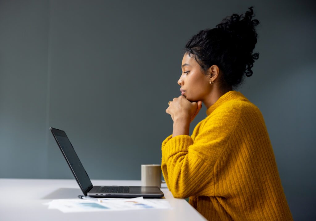 Review your Employee Value Proposition - businesswoman working on her laptop at the office and staring at her screen